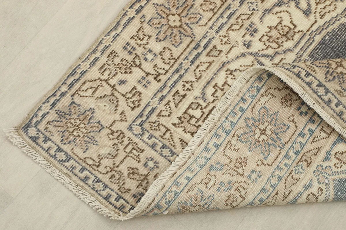 View of the rug's underside, revealing the tightly woven cotton foundation and knotting.