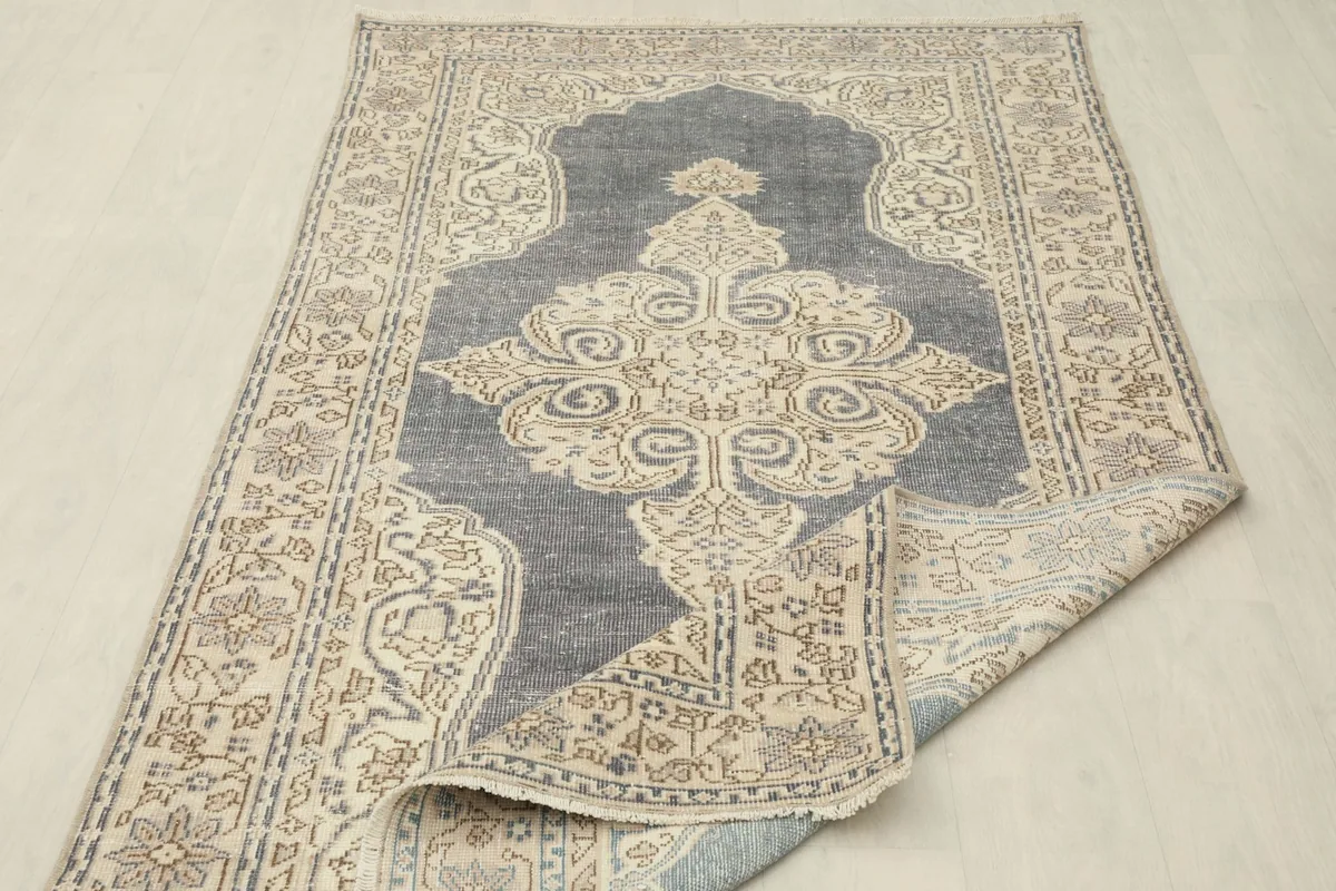 The rug partially folded to show its flexibility and the consistent design across the surface.