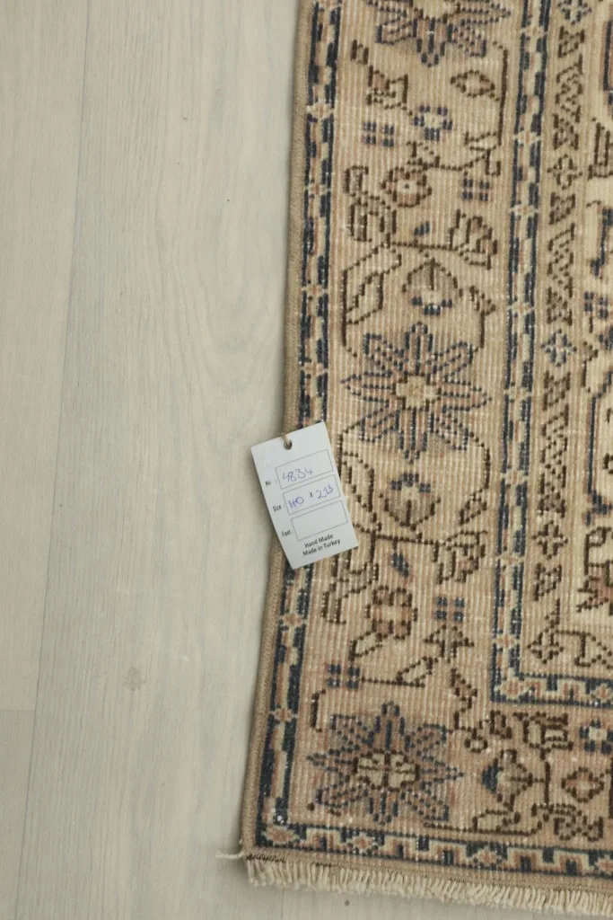 Corner of the rug with a product tag, displaying details and craftsmanship.
