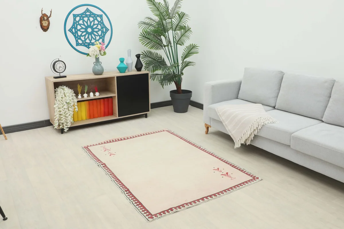 Ivory and red vintage rug placed in a modern living room setting with a light gray sofa