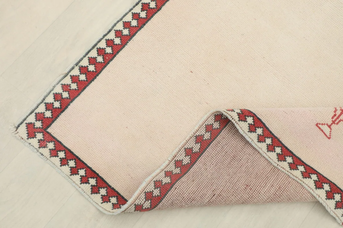 Corner of the rug folded back, revealing the wool pile and cotton foundation