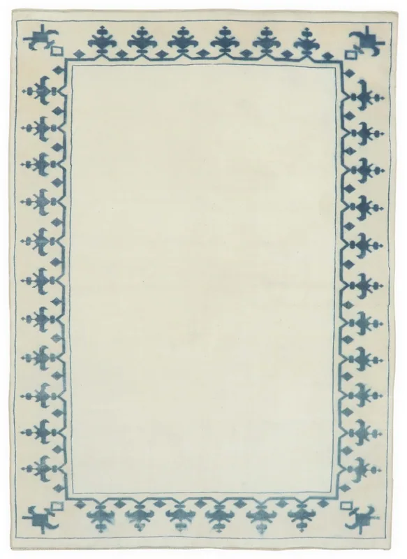 Top view of a vintage 5x8 Anatolian rug with an ivory field and blue geometric border