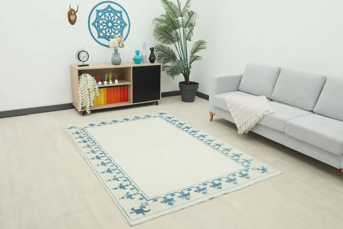 Ivory and blue vintage rug in a modern living room setting with a gray sofa