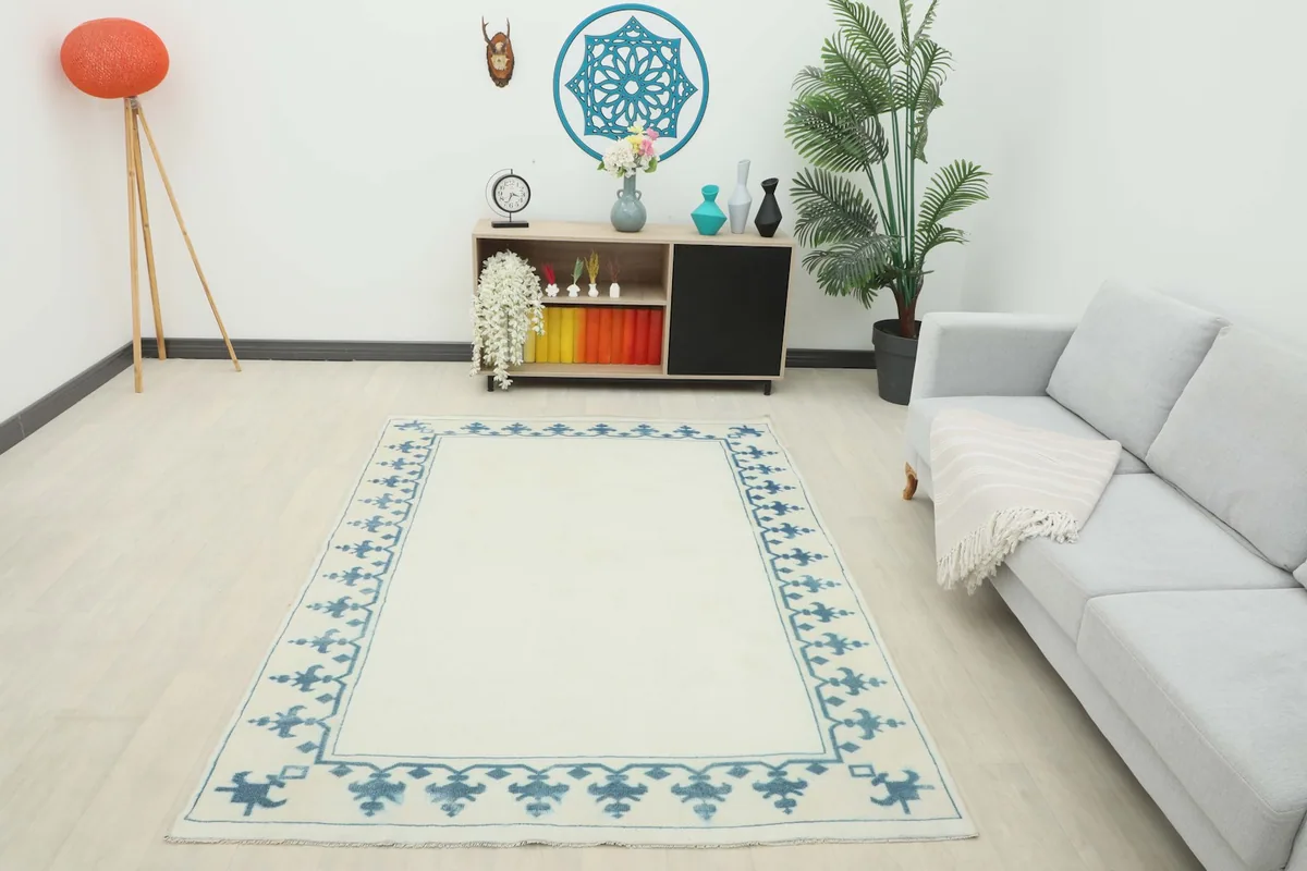 Full room view of the ivory and blue vintage rug, providing scale and context