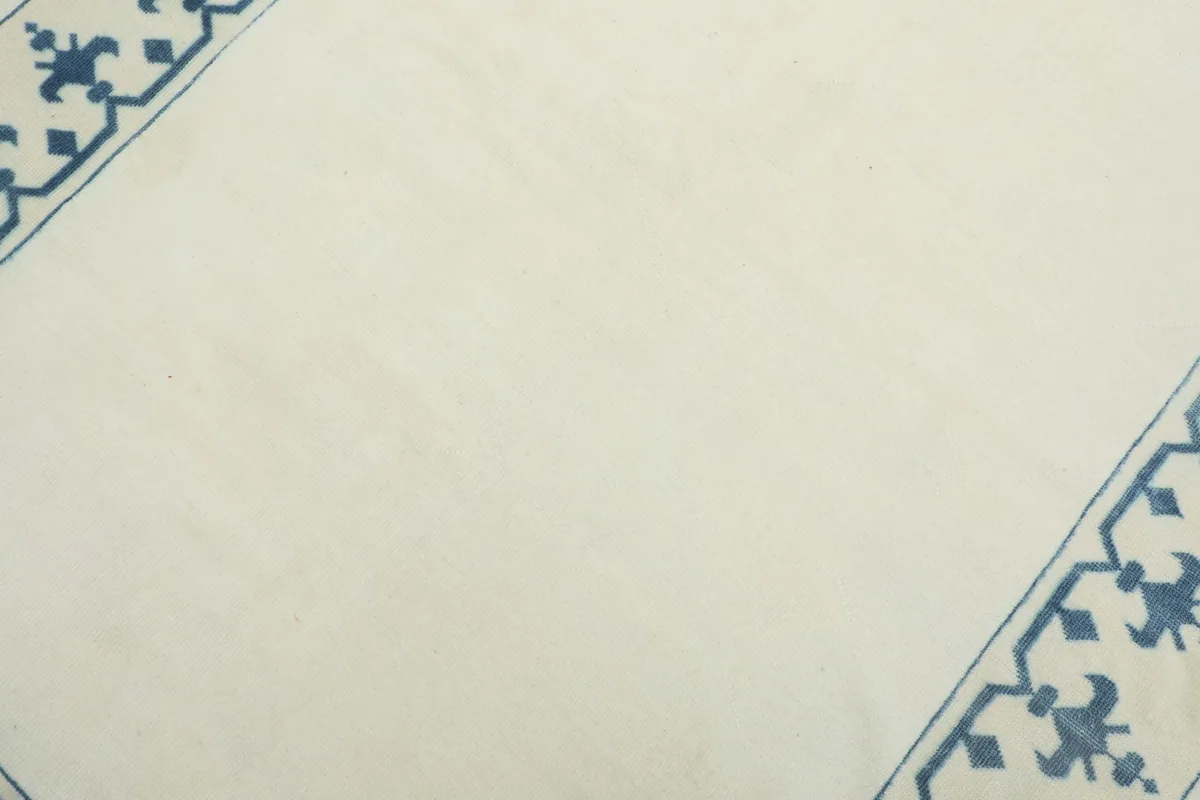 Detail shot of the ivory field and parts of the blue border, showcasing the texture