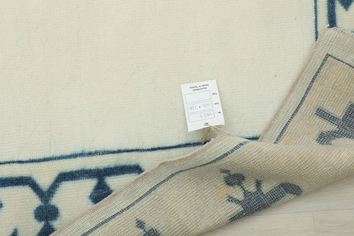 Close-up of the rug's corner with a product tag attached, showing construction details