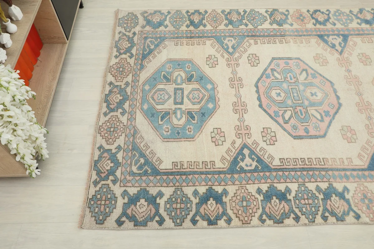 Close-up angle view of the bottom left section of the rug, showing the geometric motifs and border.