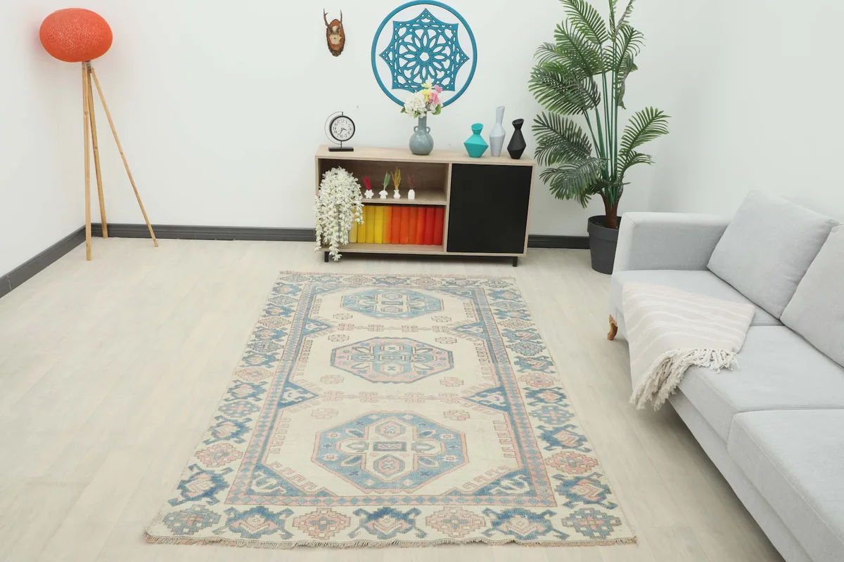 Full room view of the vintage ivory, blue, and pink rug, providing context for its size and style.