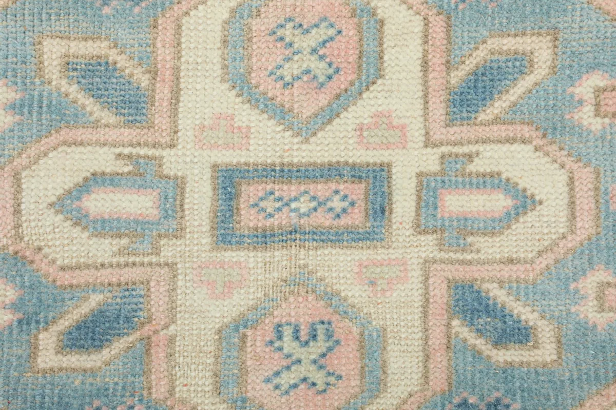 Close-up showing the texture and low pile of the hand-knotted wool on the rug's surface.