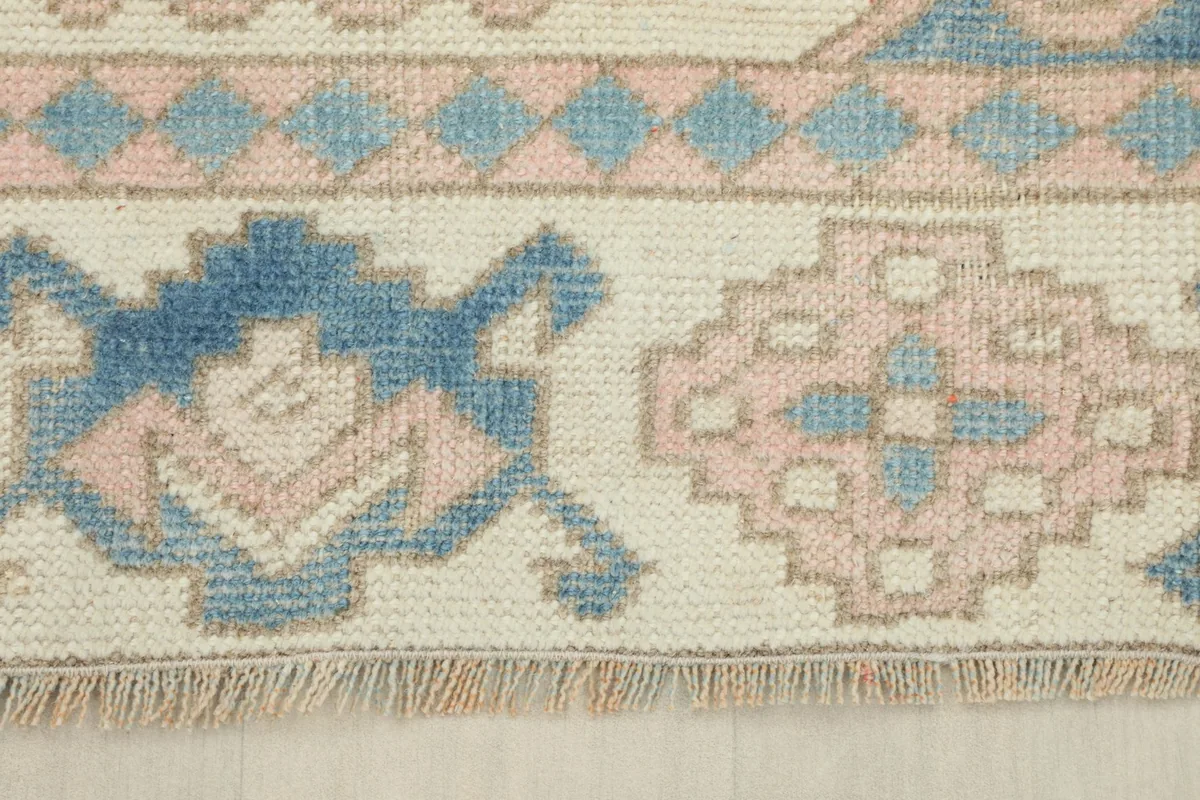 Detail of the short, natural fringes and the edge of the vintage Anatolian rug.