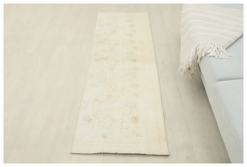 Full overhead view of the 1'9" x 6'5" cream and tan vintage runner rug on a white background.