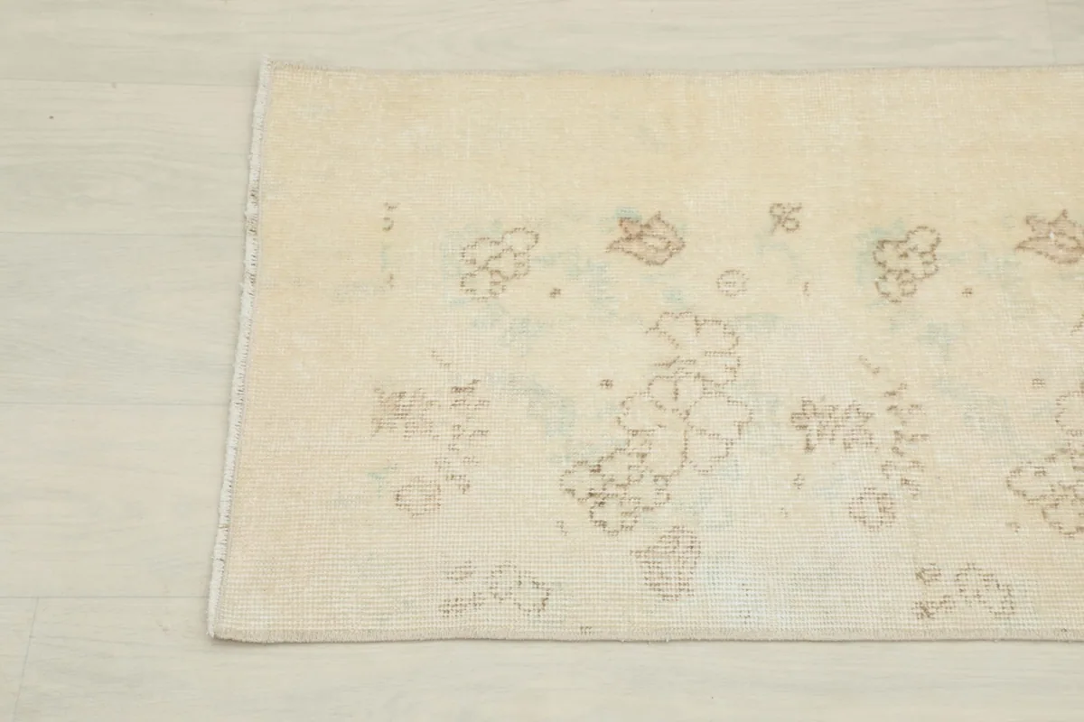 Detailed view of the middle section of the rug, revealing the soft, muted floral designs.