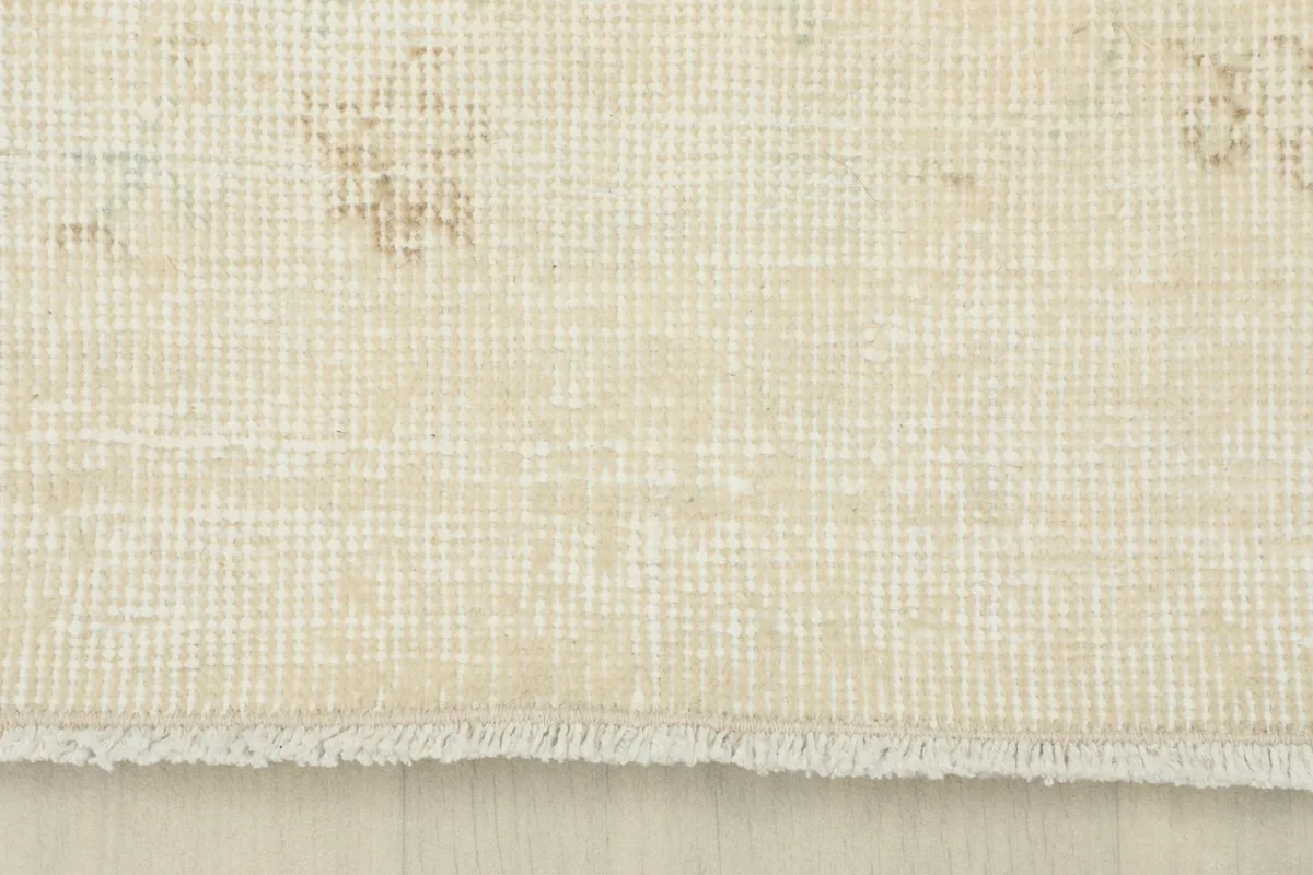 View of the rug's end, showing the short, natural cotton fringe and foundation weave.