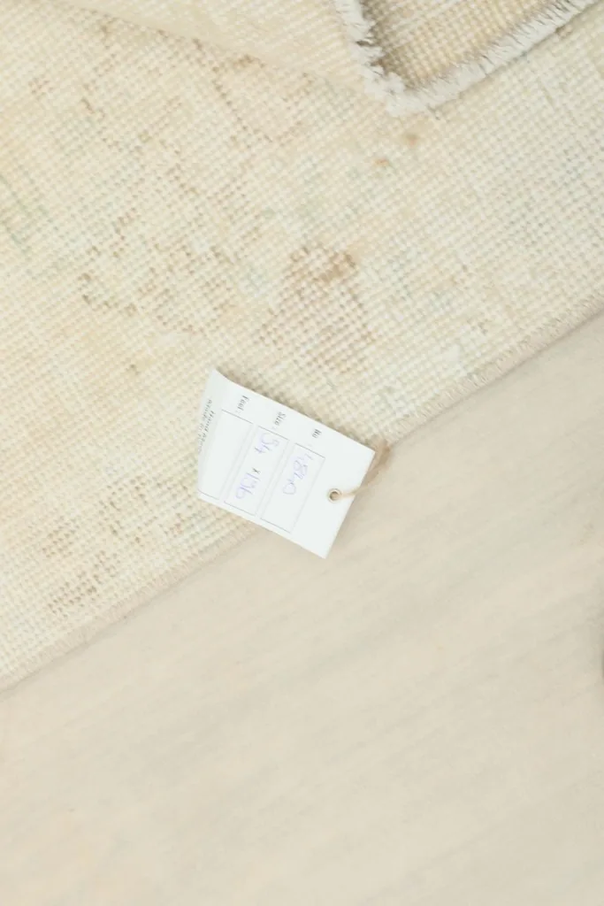 Close-up of the product tag attached to the rug, showing details like size and material.