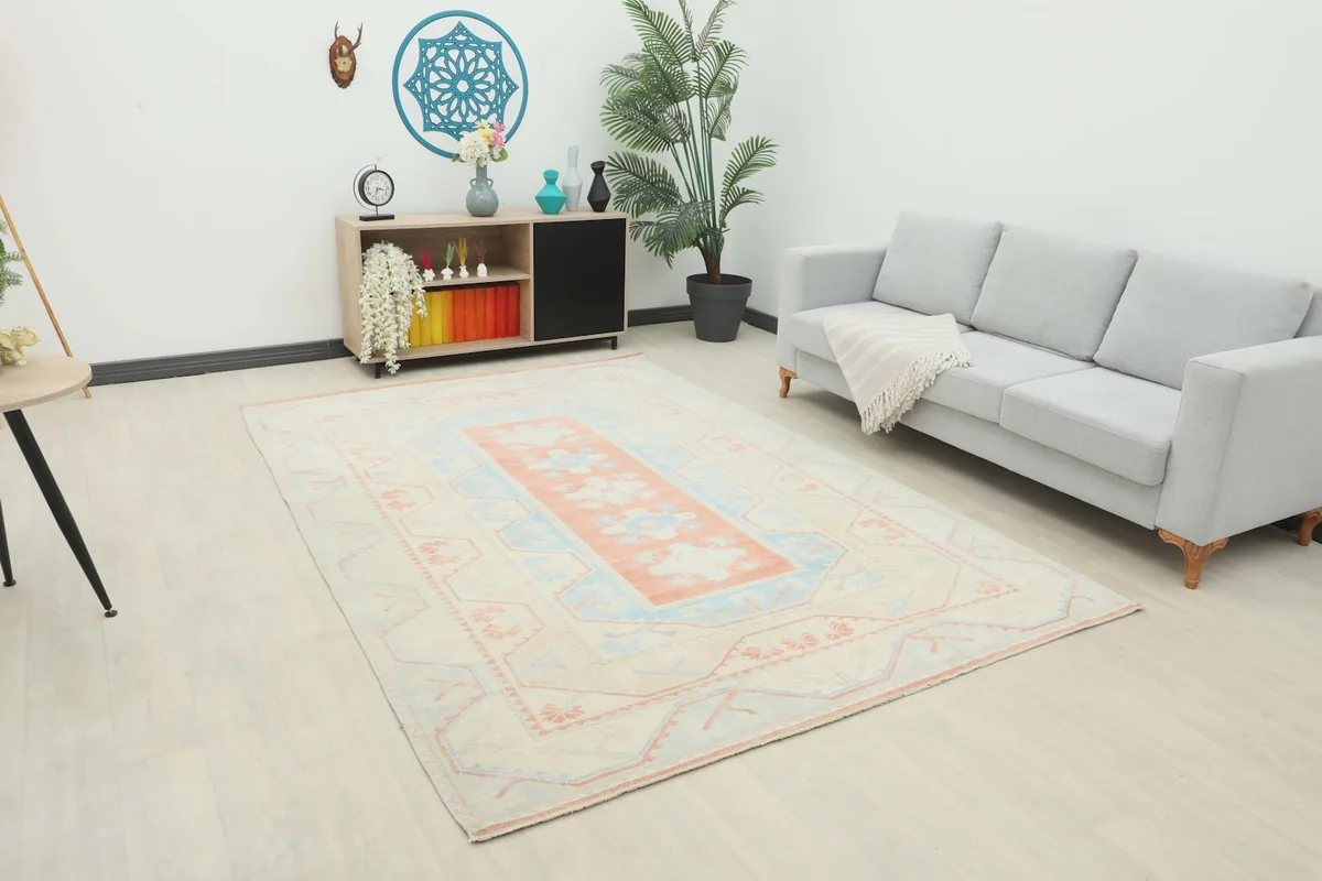 Vintage Anatolian rug displayed in a modern living room setting with a sofa and console.