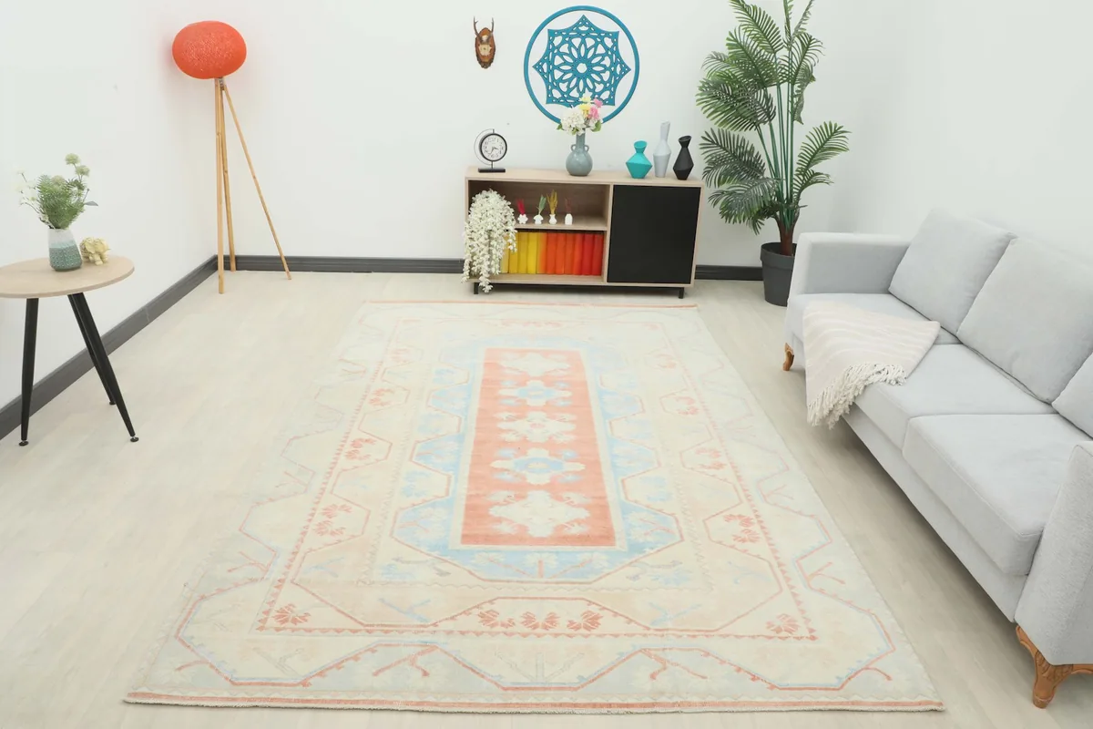 Full room view of the beige, rust, and blue vintage rug as a central design element.