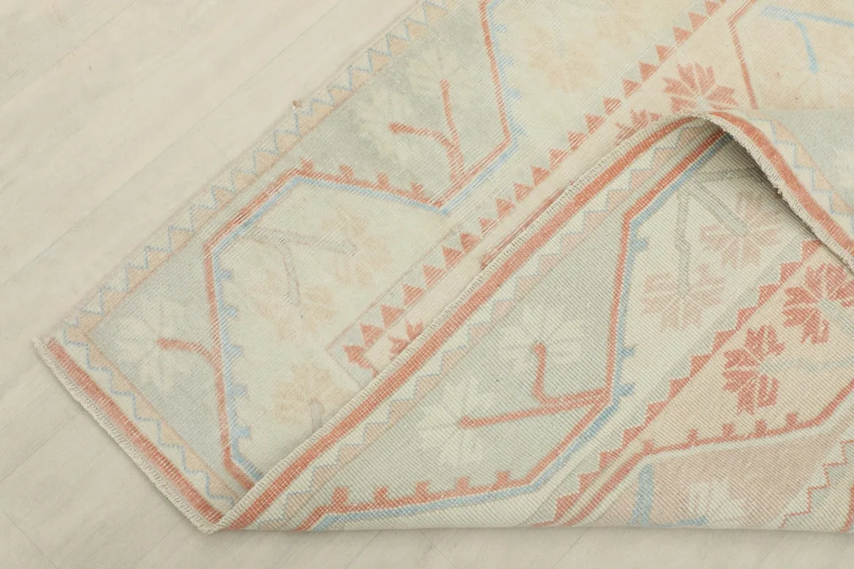 View of the rug folded back, showing the backside of the hand-knotted construction.