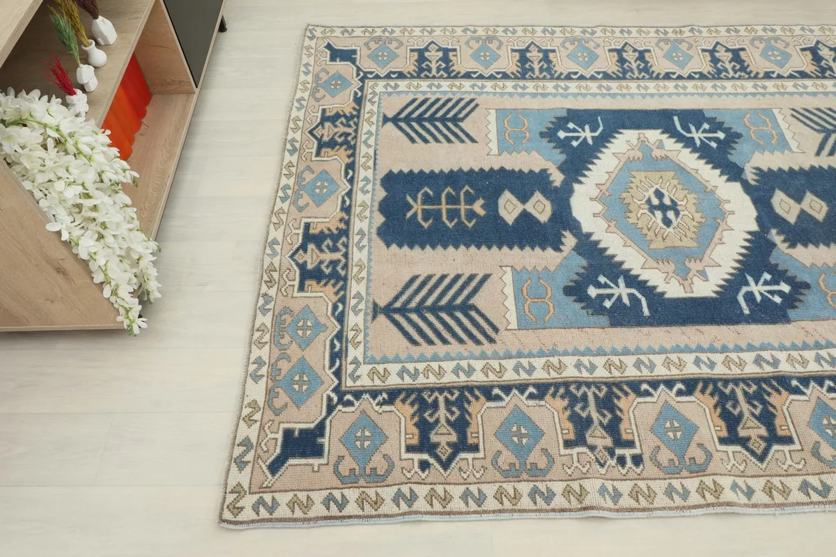 Close-up angle of the rug showing the intricate geometric motifs in navy, blue, and beige