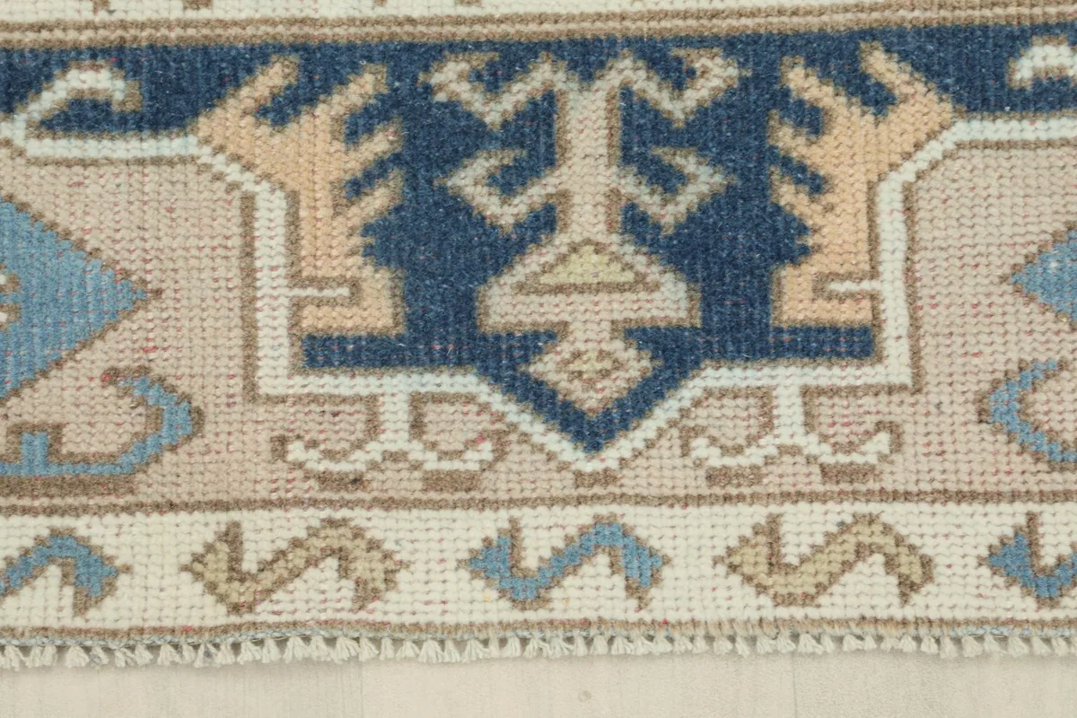 Close-up of the rug's border, revealing the different pattern bands and fringe detail