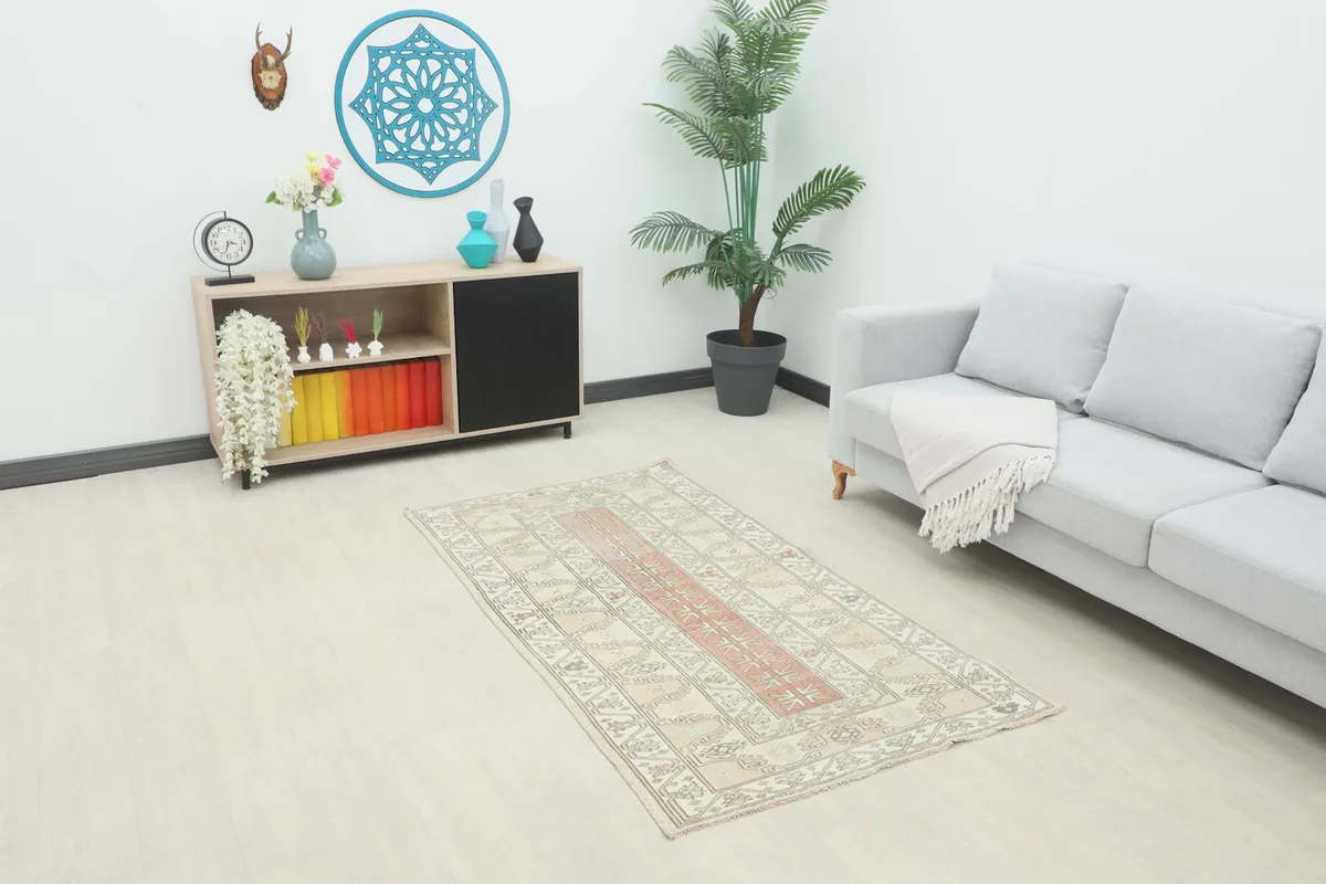 Vintage ivory and rose rug displayed in a living room setting with a light gray sofa