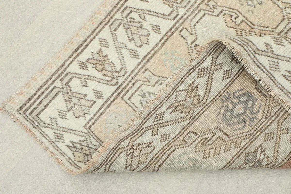 View of the back of the rug, showing the cotton foundation and construction