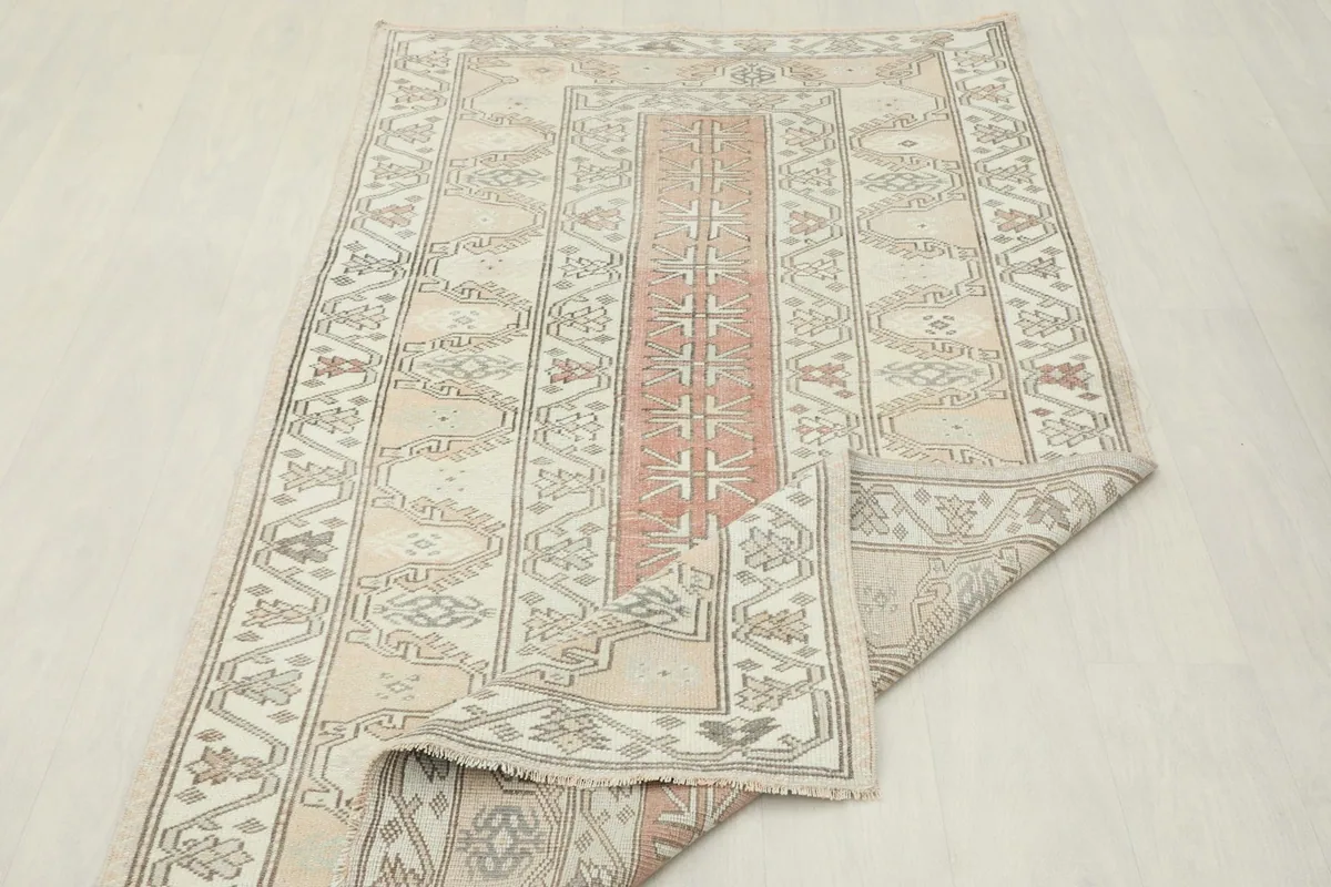 Rug partially folded, displaying the flexibility and thickness of the vintage wool pile