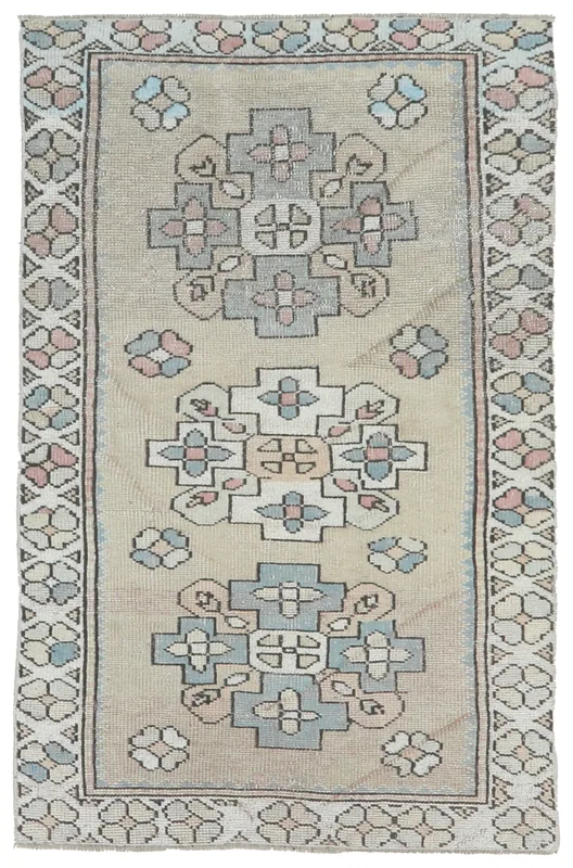 Full top view of the beige, rose, and blue vintage Anatolian hand-knotted wool rug.