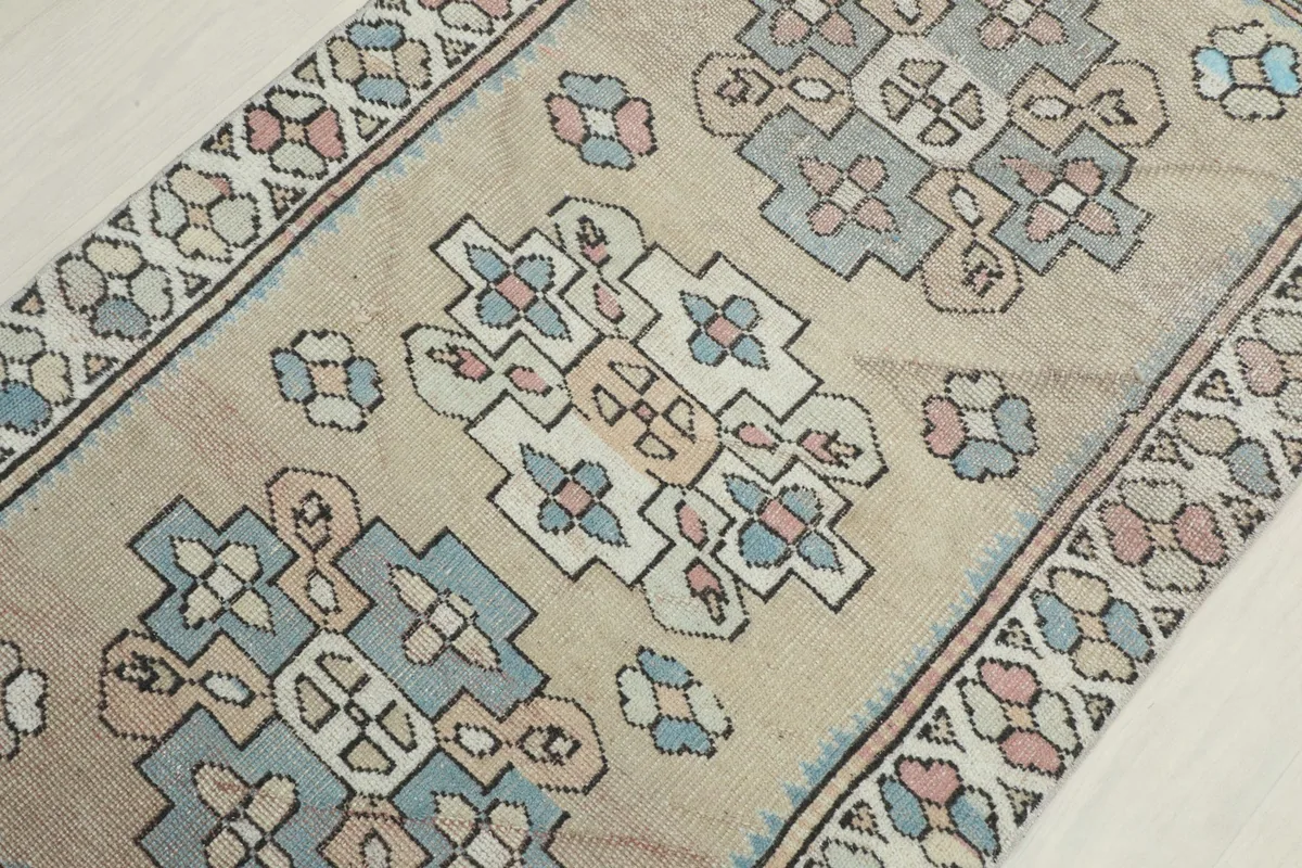 Angled close-up of the rug's center, revealing the intricate hand-knotted geometric designs and color variations.