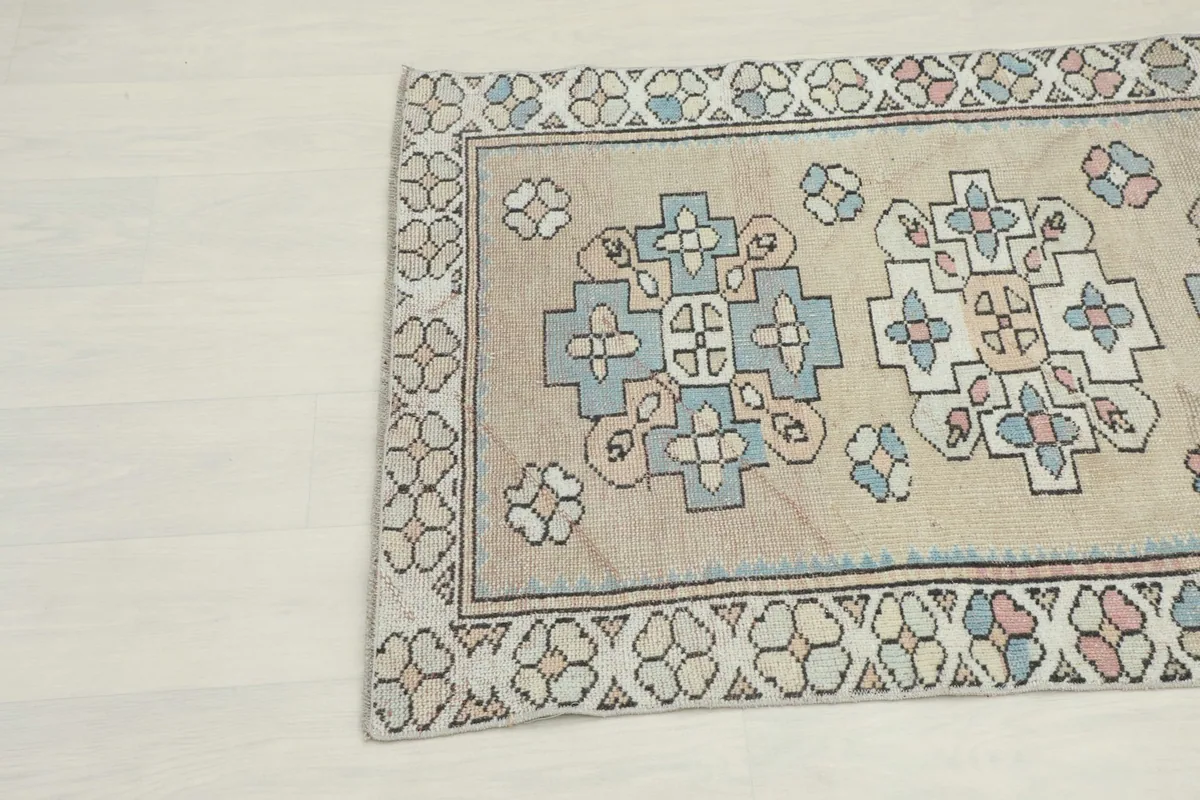 Close-up view of the upper left section of the rug, showing the stylized floral border and central motifs.