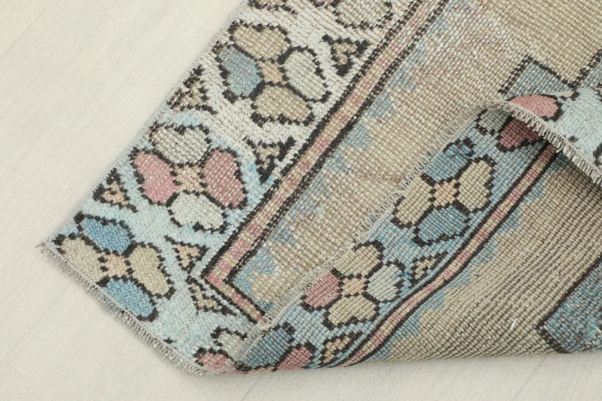 View of the rug's underside, revealing the hand-knotted cotton foundation and reverse side of the pattern.