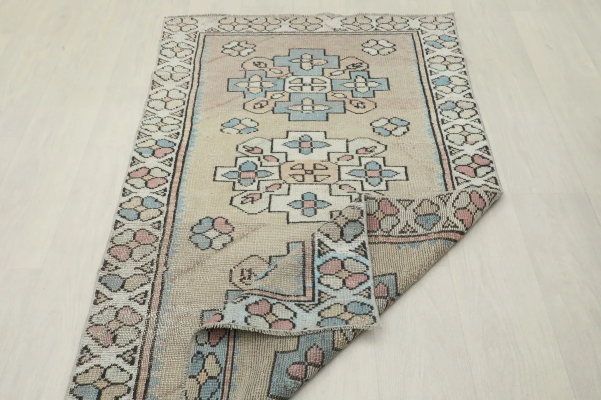 The vintage rug folded to show its flexibility and the consistent pattern from different angles.