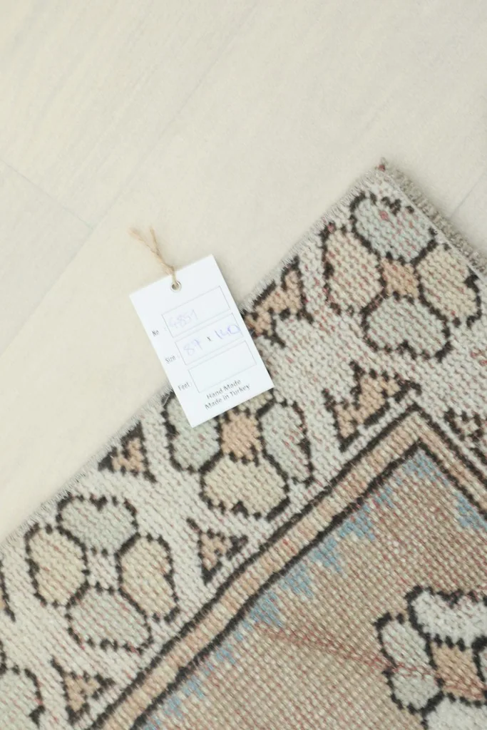 Corner of the rug with a product tag, indicating its origin and material.