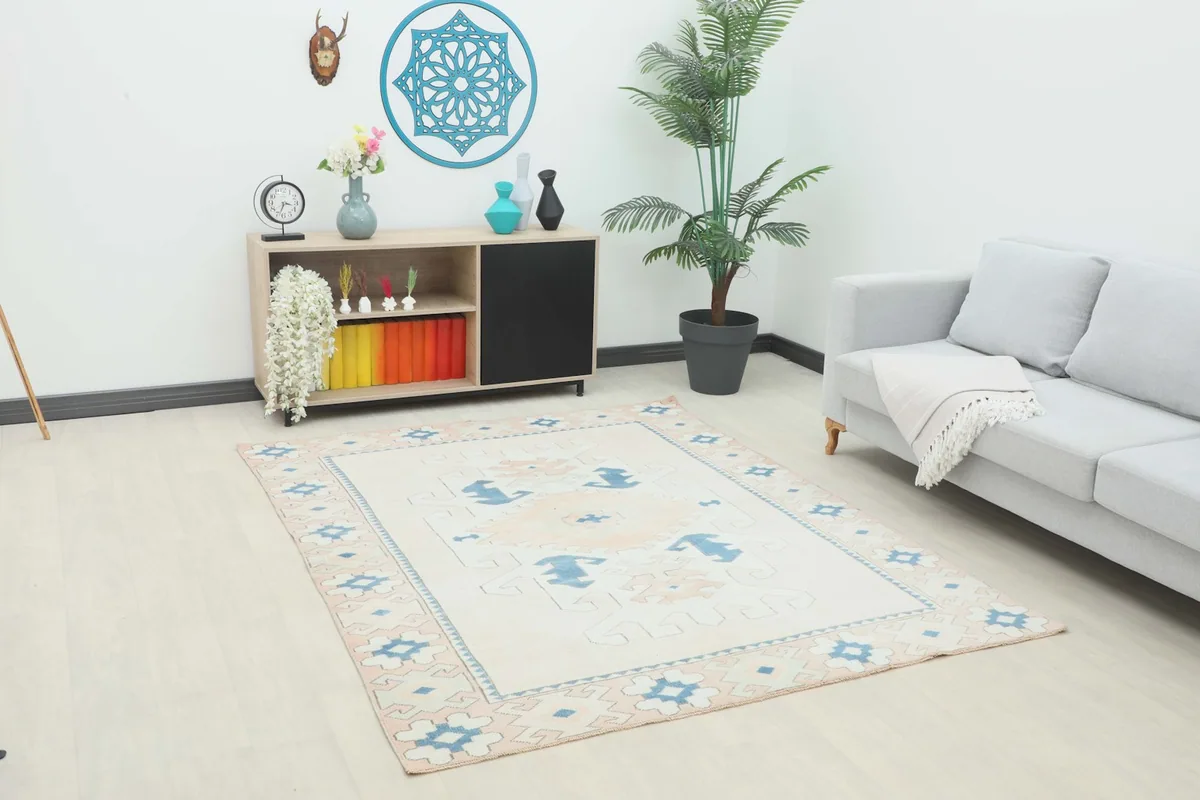 Vintage Anatolian rug displayed in a living room setting with a light gray sofa and wooden cabinet.