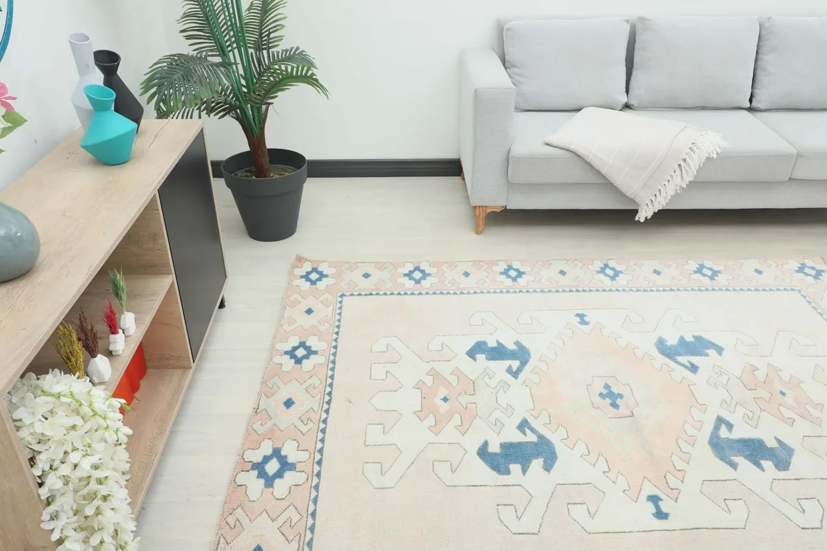 Overhead view of the vintage rug in a room, showing its placement relative to a sofa and cabinet.
