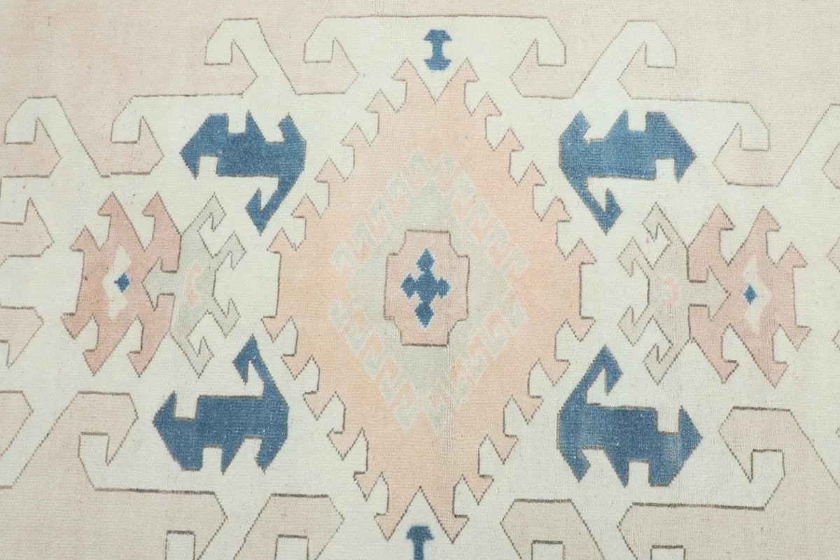 Detailed view of the central beige field with rose and blue tribal and geometric motifs.