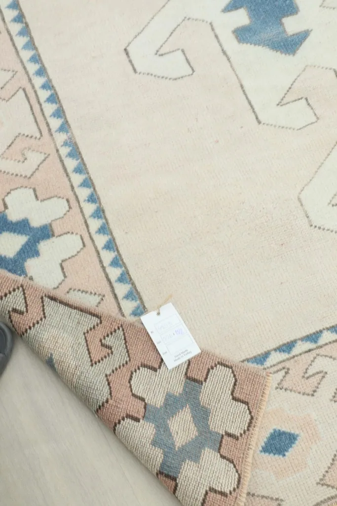 View of the rug's back and a label, showing the quality of the hand-knotted craftsmanship.