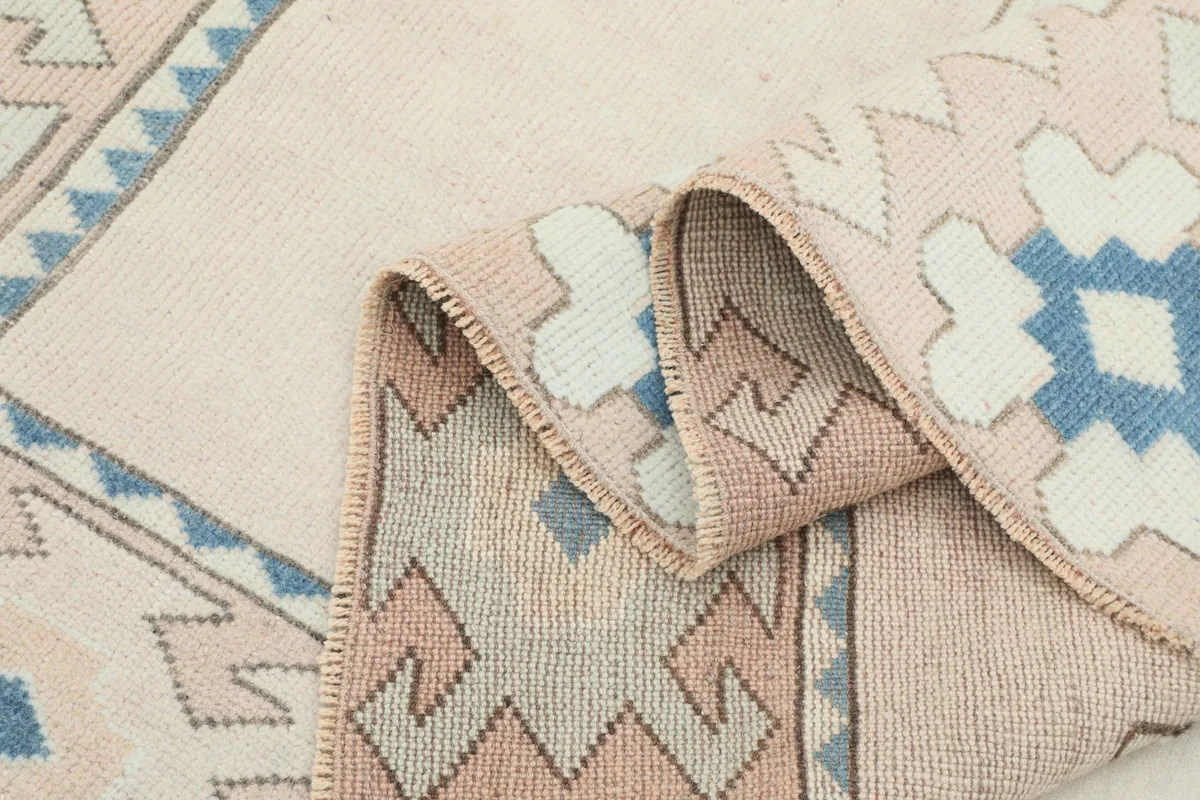 Another folded section of the rug, showing the wool pile texture and the cotton foundation.