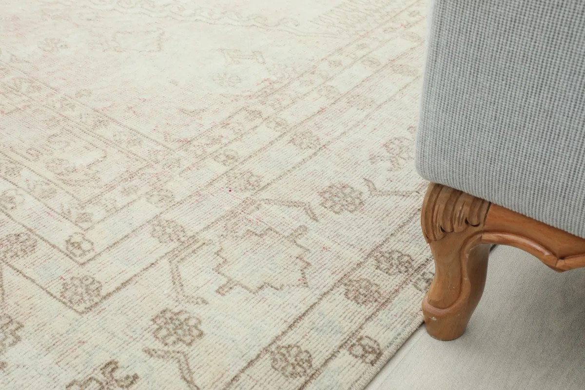 Rug detail next to a wooden furniture leg, illustrating its scale and how it complements home decor.