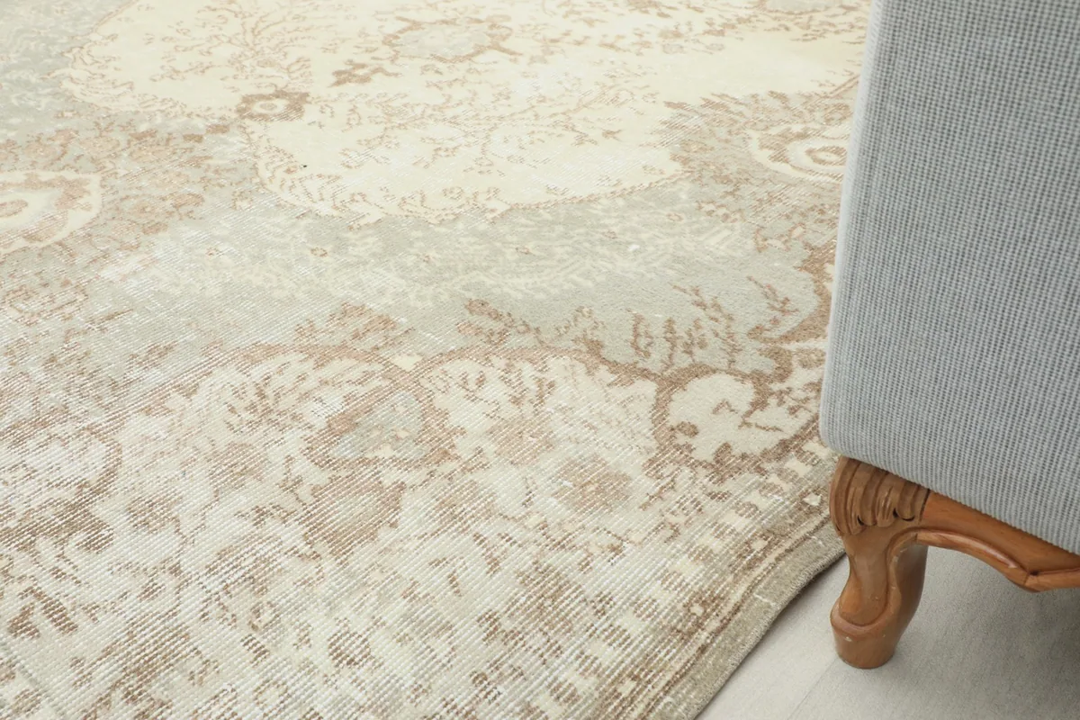 Close-up of the rug's edge next to a sofa leg, showing its integration into a living space.