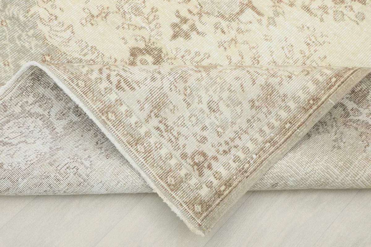 Corner of the rug folded to show the hand-knotted cotton foundation and reverse side.