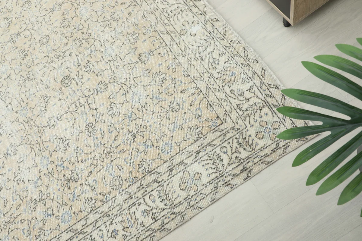 Corner detail of the rug's border, revealing the layered floral and geometric patterns.