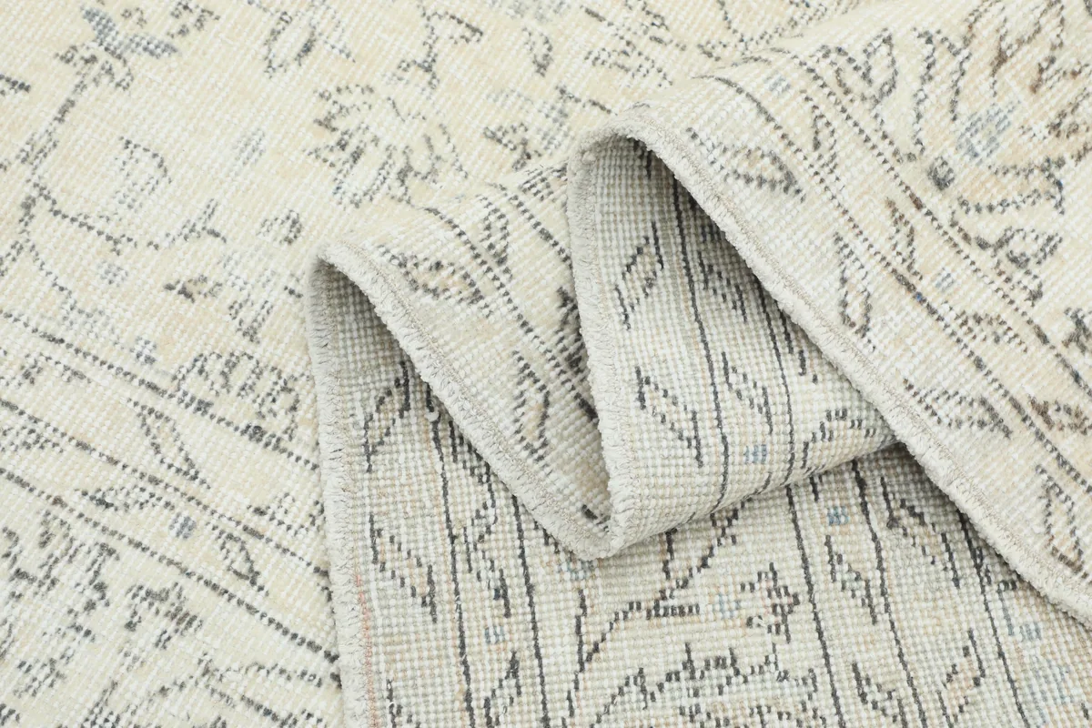 Close-up of the rug's low pile and weave structure, with a gentle fold.