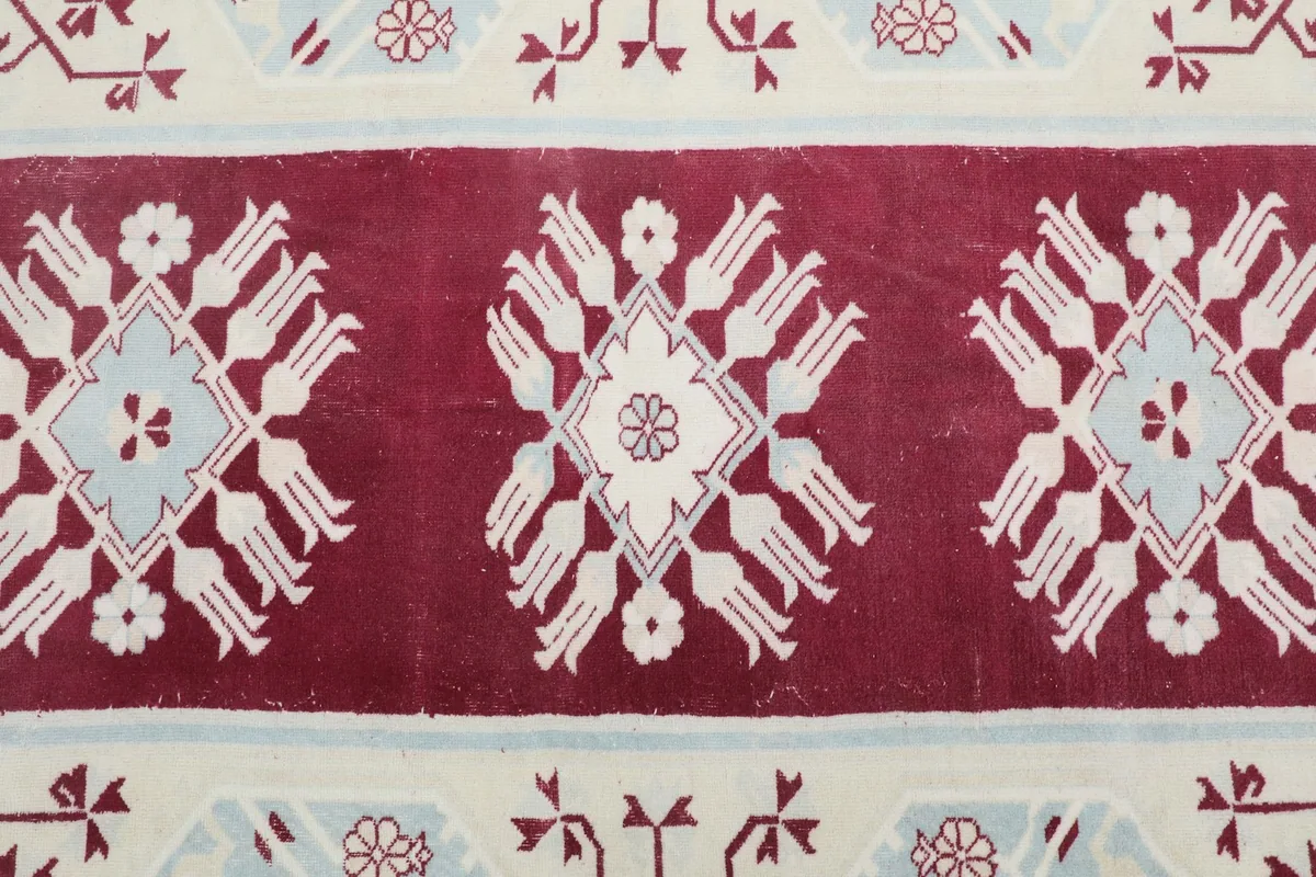 Detailed view of the central red panel with ivory and blue geometric patterns