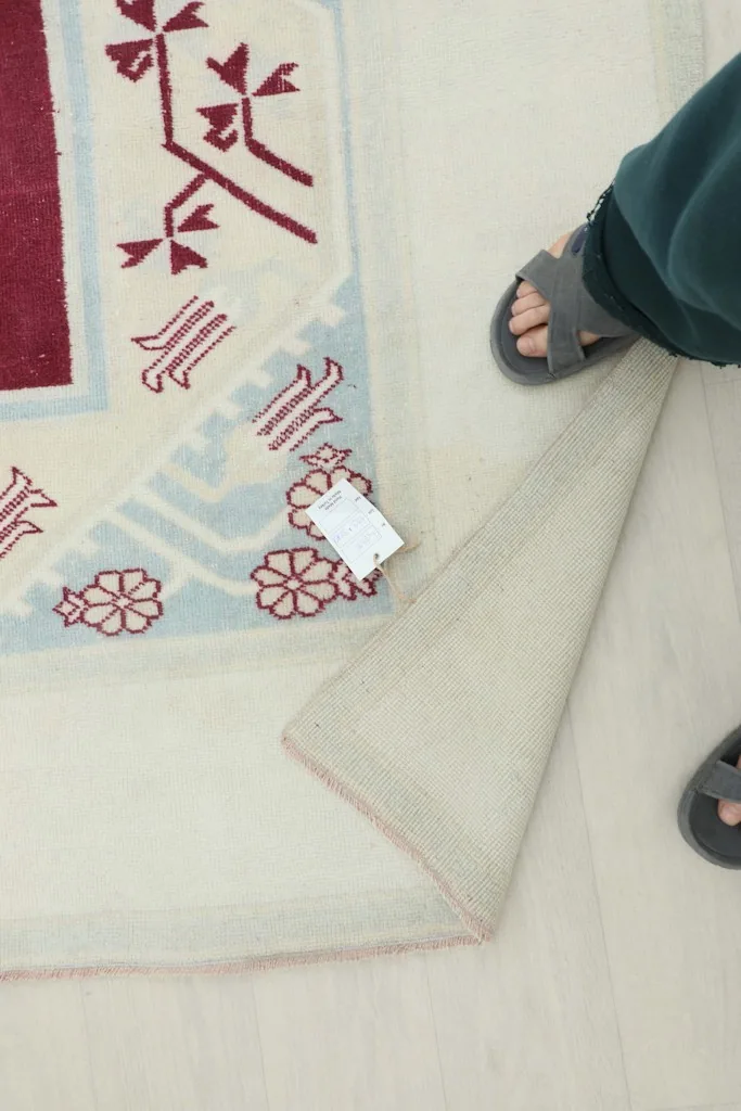 Foot resting on the rug, indicating the soft texture and low pile