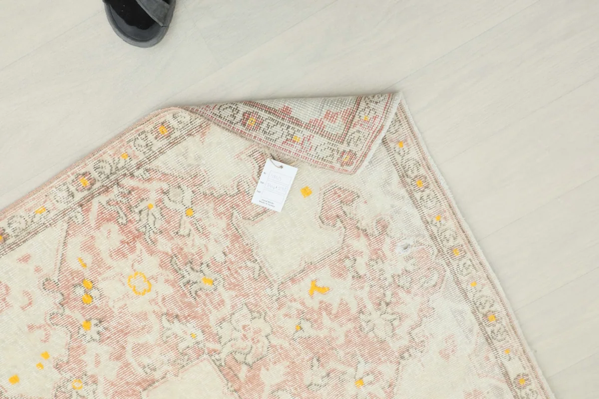 Overhead view of the rug with a tag, emphasizing its full pattern and condition.