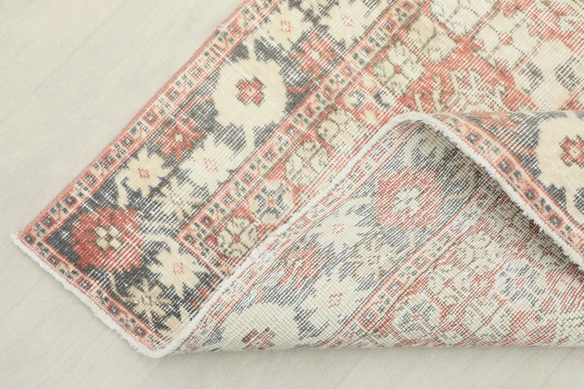 Corner of the rug folded back to show the cotton foundation and reverse side of the hand-knots