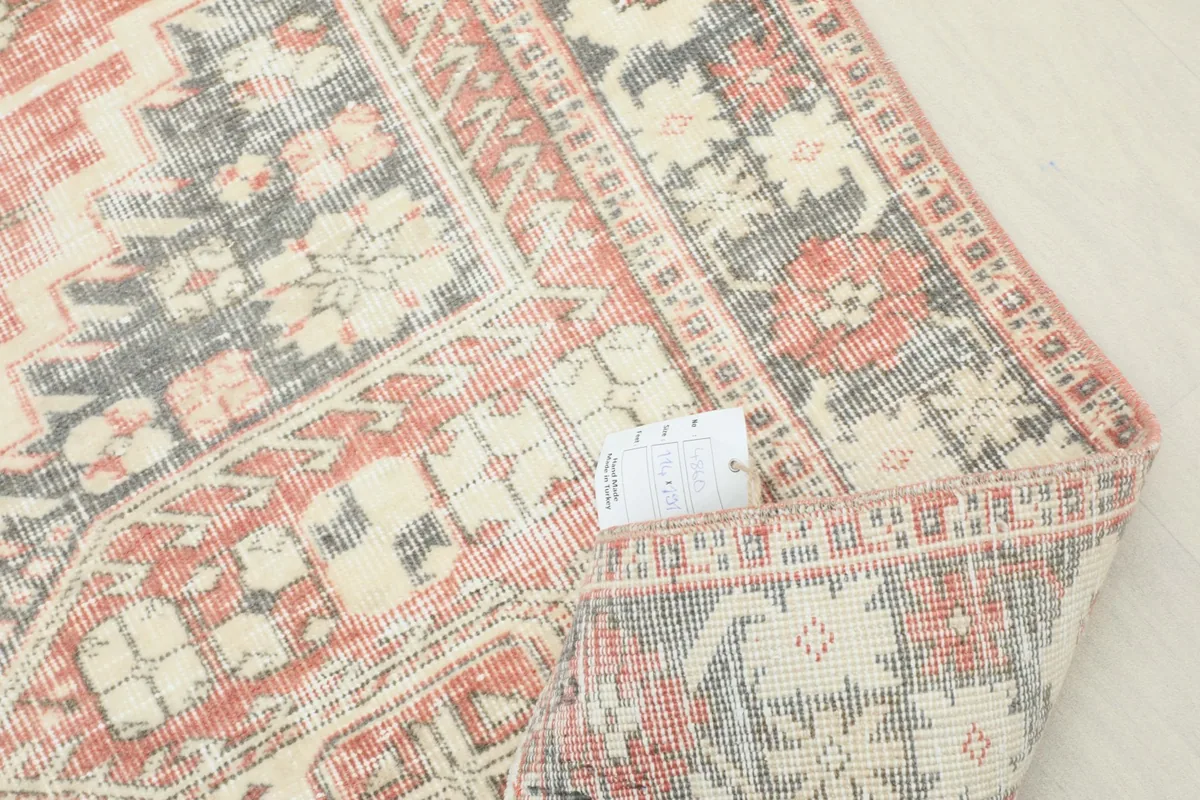 Corner of the rug folded back with a tag showing product information and quality