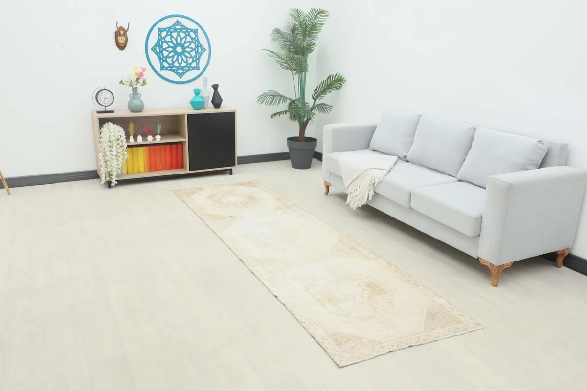 Vintage Anatolian runner rug in a room setting next to a light gray sofa and modern cabinet