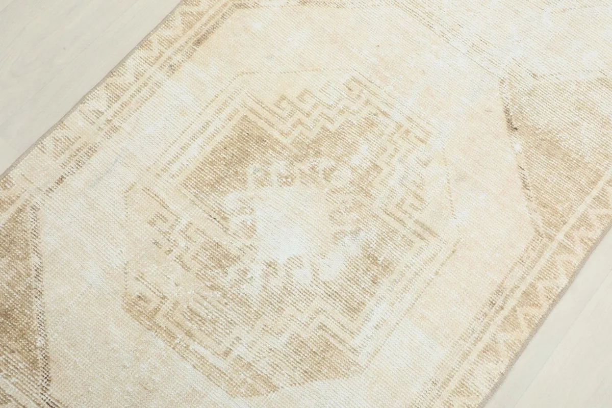 Overhead close-up of a central geometric medallion showing the worn low pile texture