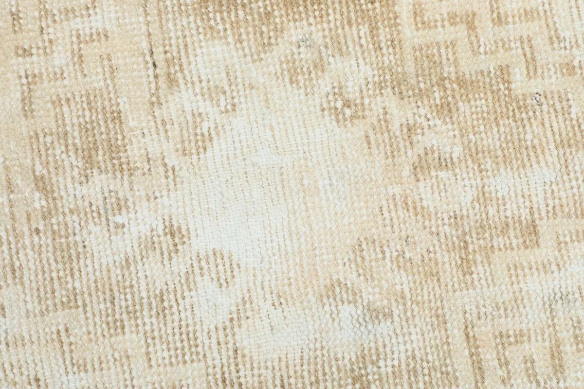 Extreme close-up of the hand-knotted wool pile, showing its low height and vintage patina